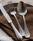 Vintage INOX baguette cutlery set featuring a classic knife, fork, and spoon on a brown napkin, ideal for casual to formal occasions.