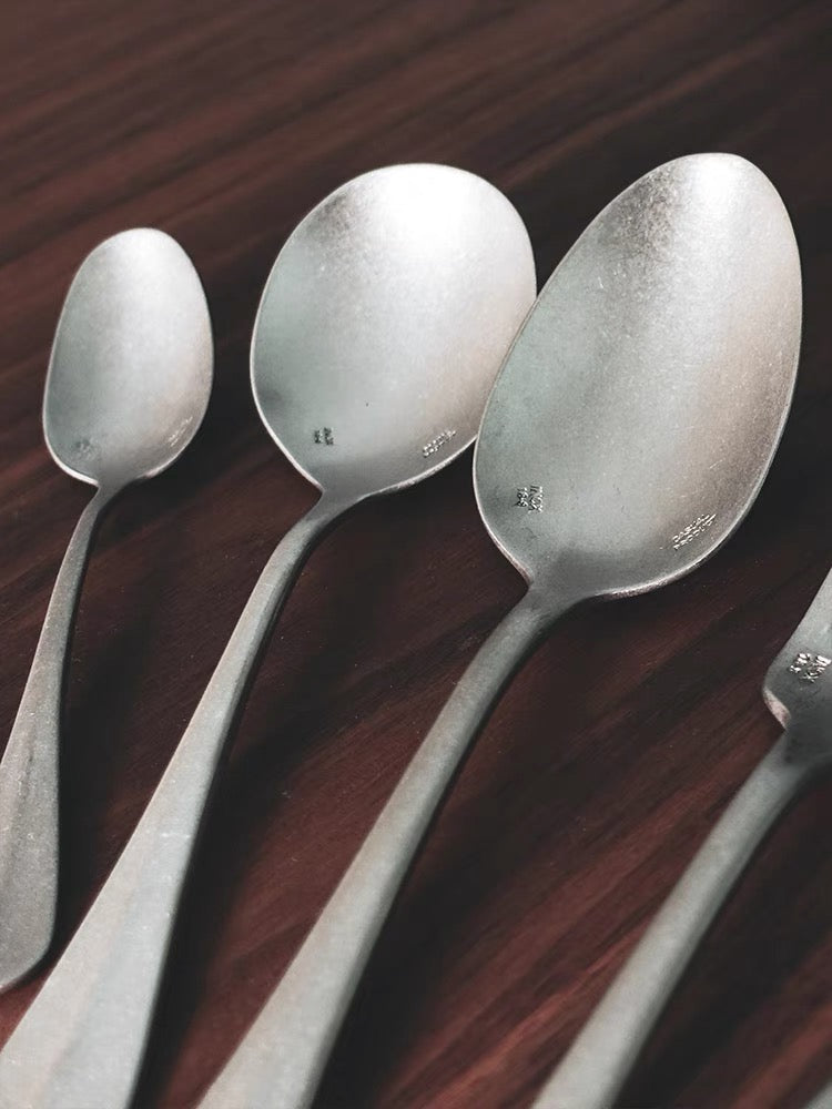 Vintage Inox Baguette Classic Series cutlery spoons with elegant design on a wooden table.