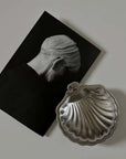 Vintage Metal Shell Box closed, beside a black and white photograph