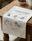 Café de LoveÉcru cotton napkin draped on a table beside a bowl of berries