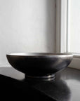 Kyoto Stainless Steel Bowl on a black table by a window