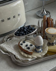 Signature Serving Tray with a toaster, blueberries, a boiled egg and a latte