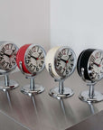 Orbit Alarm Clocks in chrome, red, beige and black on a steel shelf