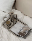 Signature Serving Tray with a French press and coffee cups on white pillows