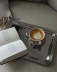 Signature Serving Tray with a cappuccino and an open book on a bed