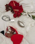 Ocean Bundle pieces with red flowers on a white bed