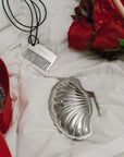 Ocean Bundle shell trinket case and comb on a bed with roses