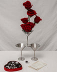 Two Stainless Steel Martini Glasses beside a vase of red roses