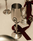 Stainless Steel Champagne Flutes with a dark red ribbon on a table