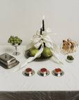 Stainless Steel Egg Cups on a table set with a butter dish, pears and candles