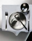 Stainless steel plate from the Set of Six with a steel bowl and cutlery on a napkin