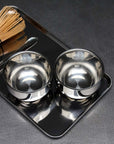 Spherical Cups set of two on a steel tray with a bamboo matcha whisk