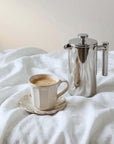 Morning Reflection Set: mirror French press with the white Rinka mug on a bed