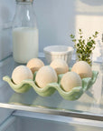 Green Ceramic Wavy Egg Tray with six eggs on a fridge shelf