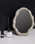 Nordic cloud-shaped vanity mirror with unique frame, measuring 27x20cm, displayed next to home decor items on a dark background.