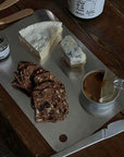 Minimalist Stainless Steel Cutting Board with cheese, crackers and a knife