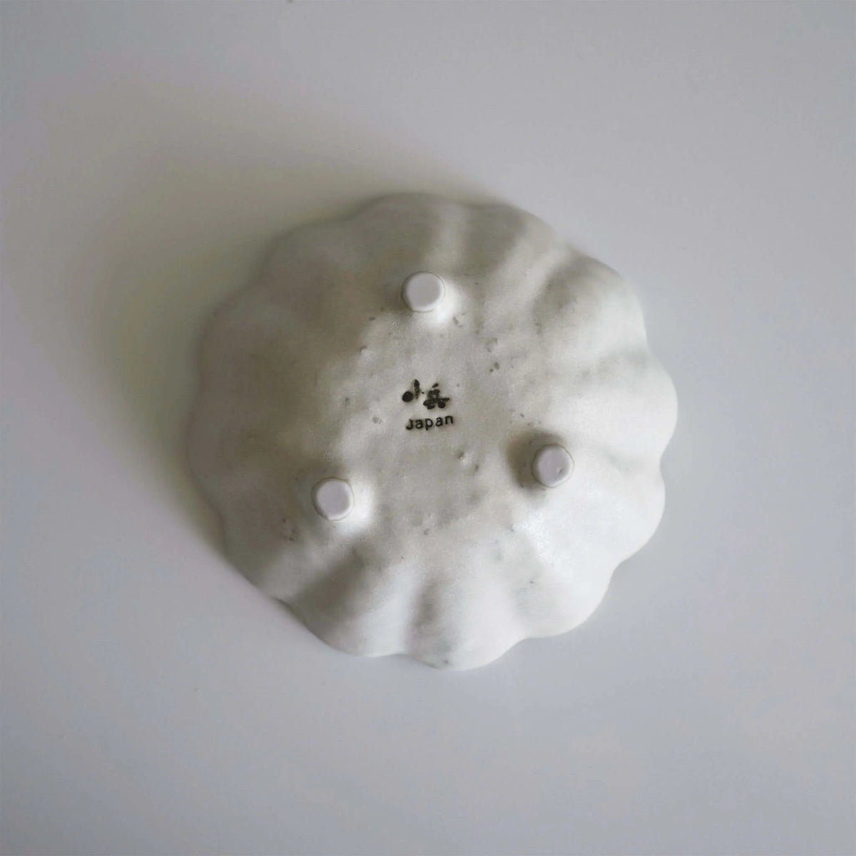 Underside of the White Rinka 12 cm bowl, showing the Japan stamp and three feet.