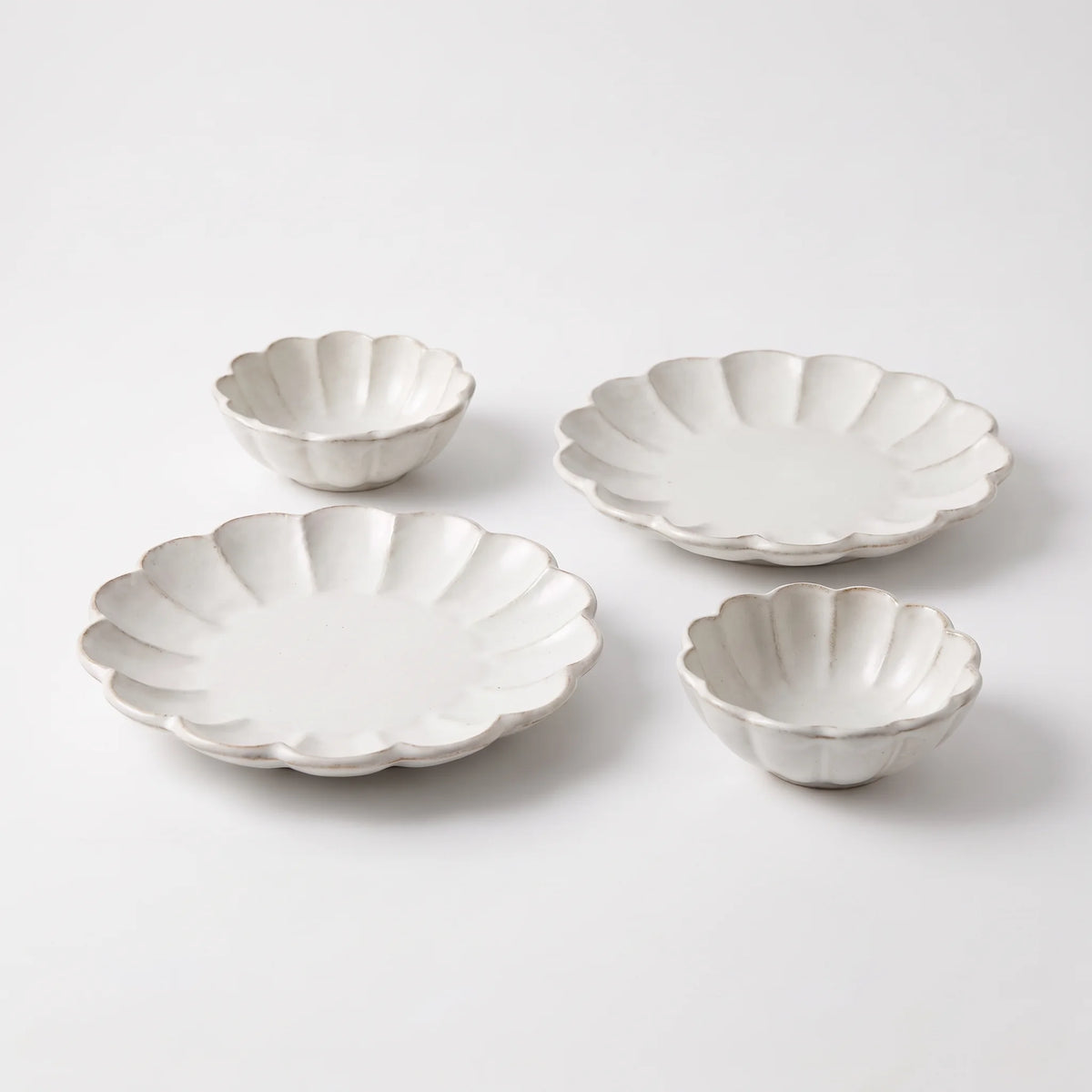 Two white Rinka 21 cm plates and two white 12 cm bowls on a neutral white background.