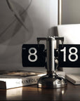 Turning desktop clock with page-turning mechanism, perfect for Japanese or Nordic interiors, on a modern desk setting.