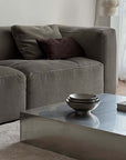 Stacked Kyoto Stainless Steel Bowls on a coffee table beside a grey sofa