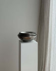 Stack of Kyoto Stainless Steel Bowls on a white plinth beside curtains