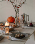 Artisan Pasta Plates on a table set for dinner with a French press and candles