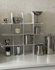 Stello Countertop Grid Shelf beside an espresso machine with steel cups