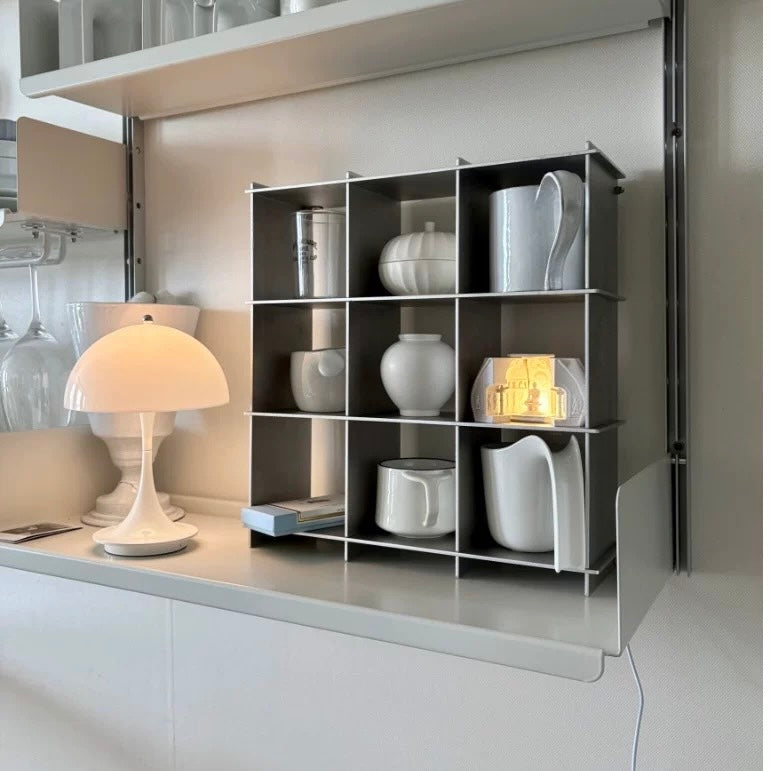 Stello Countertop Grid Shelf displaying minimalist white ceramics and a lamp in a modern kitchen setting.