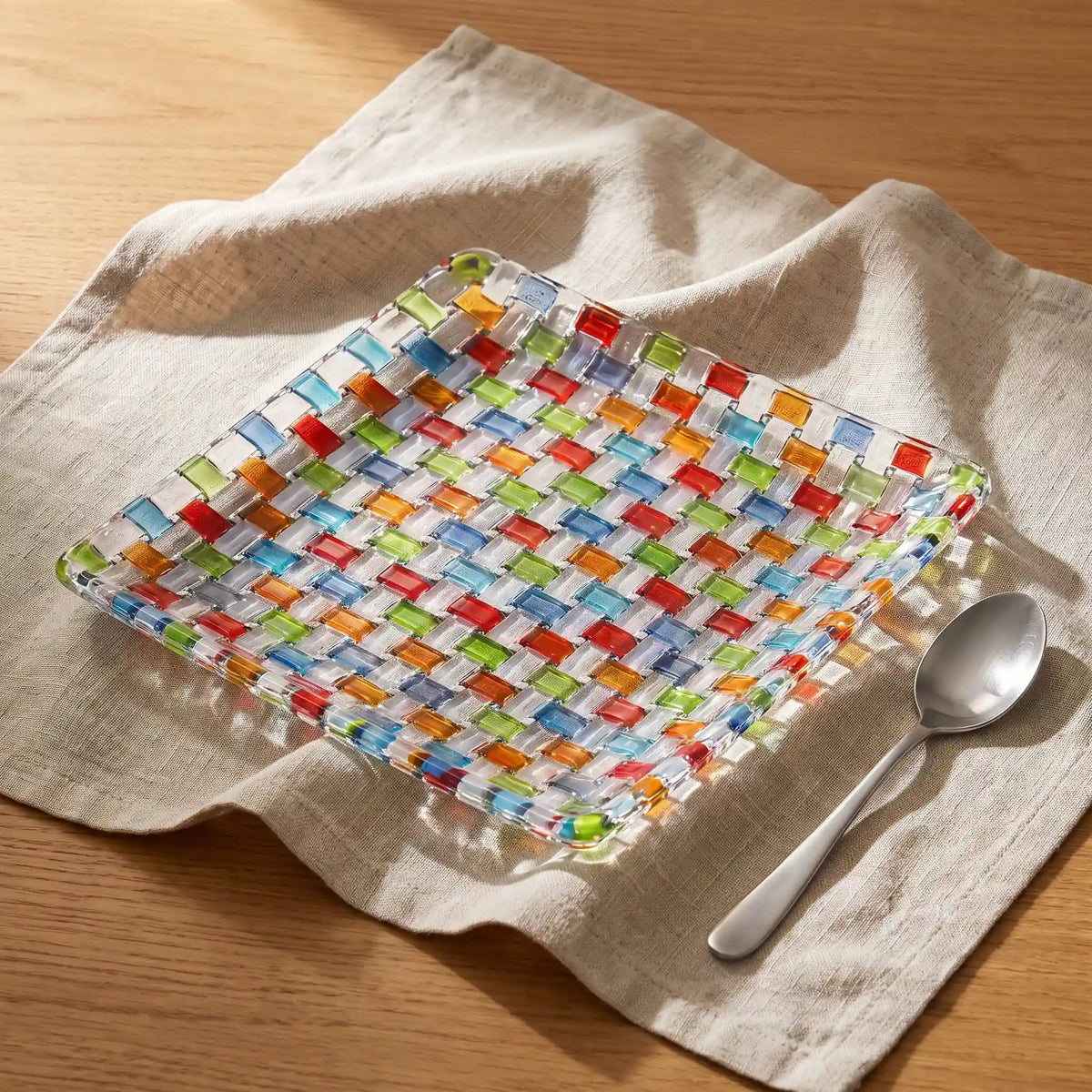 Tessera square platter with a spoon on linen, seen from above