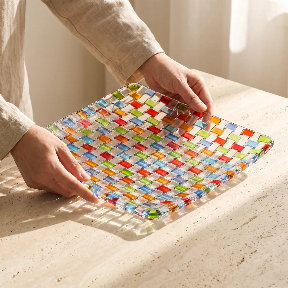 Hands placing the Tessera square platter on a stone table