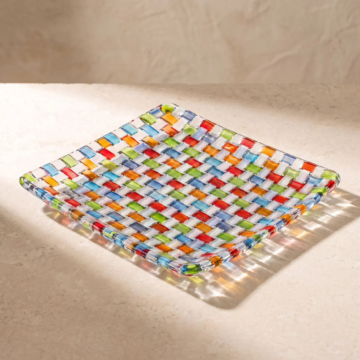 Close-up of the woven glass texture of the Tessera square platter in sunlight