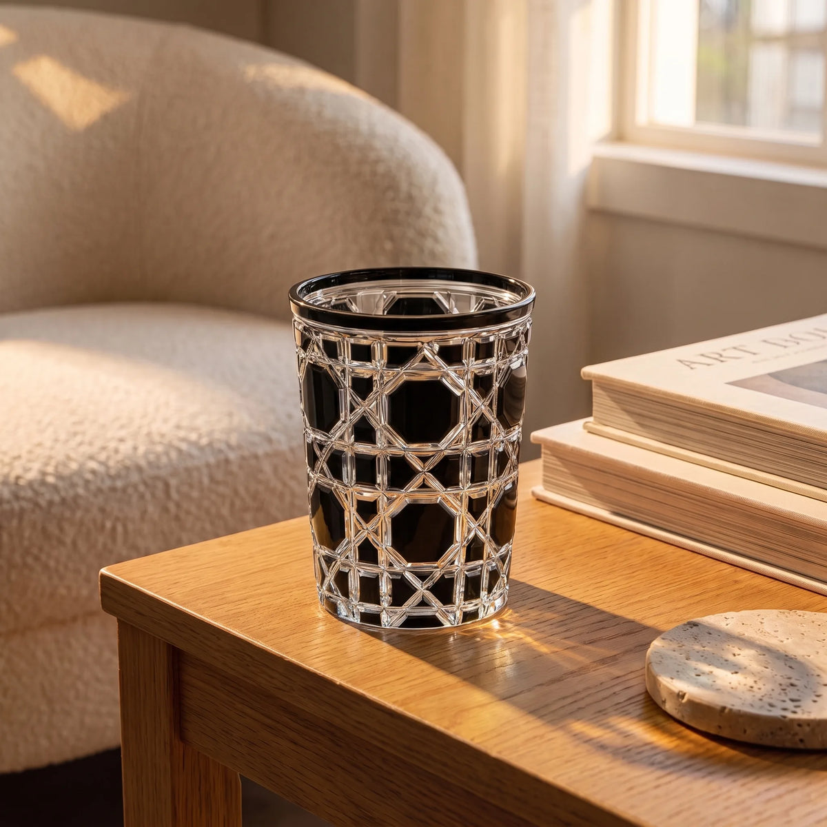 Black Vetra Lattice glass with water on an oak side table