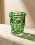 Green Vetra Lattice glass in sunlight, casting a green shadow on a stone table