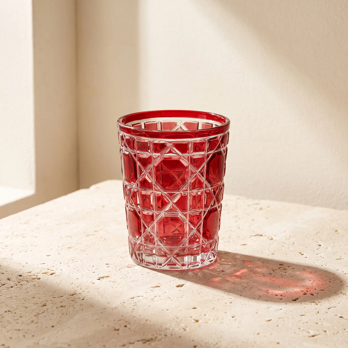 Red Vetra Lattice glass in sunlight on a stone table