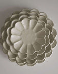 Stacked Rinka porcelain plates from Japan, showcasing exquisite craftsmanship and elegant design.