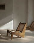 Two Kangaroo Chairs with rattan and solid wood in a minimalist room, showcasing a stylish "Z" shaped design and sleek finish.
