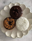 Rinka Plate 24cm with three assorted donuts on a marble surface, showcasing the elegant, handcrafted Japanese porcelain design.