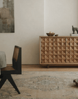Medieval sideboard cabinet with intricate design in a rustic dining room setting, featuring a decorative sculpture on top.