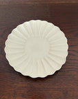 Elegant Rinka Plate by Yoshida Pottery with nature-inspired design on a wooden table. Perfect for enhancing table settings.