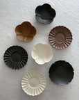 Assorted Rinka Plates by Yoshida Pottery displayed on a white surface, showcasing nature-inspired patterns and elegant designs.