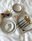 Elegant Barbarie Set with handcrafted Japanese porcelain plates and gold utensils on display, highlighting artistic craftsmanship.