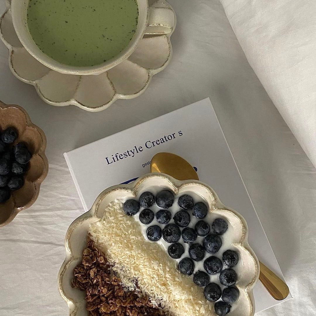 Rinka porcelain bowls with smoothie and blueberries on a table setting, showcasing the artistic design and elegance of the collection.